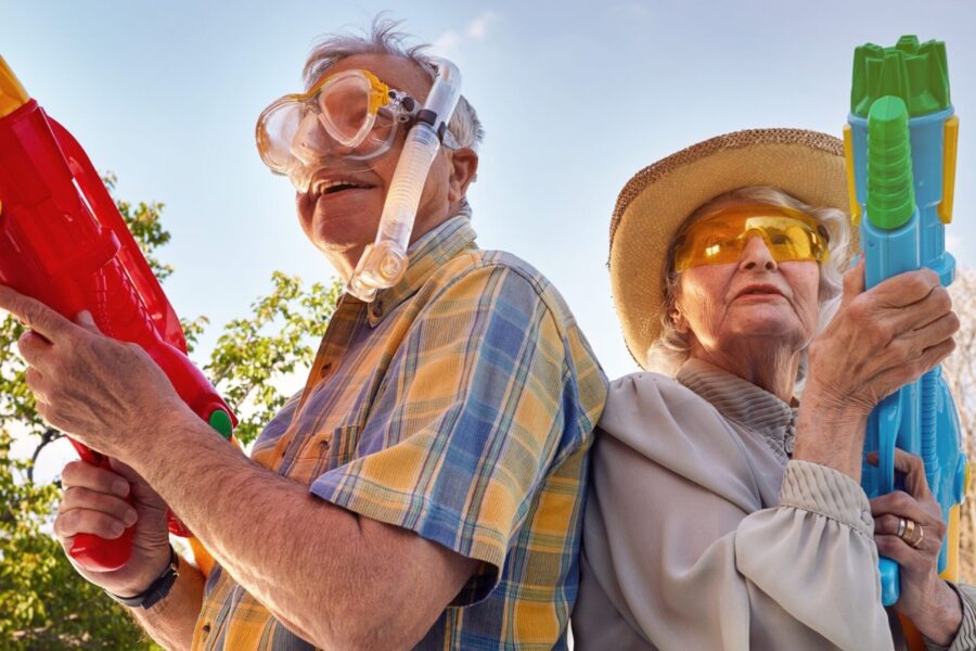 een oudere man en vrouw die met speelgoedgeweren aan het spelen zijn