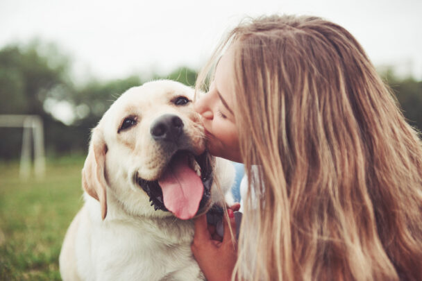 vrouw geeft hond een kus