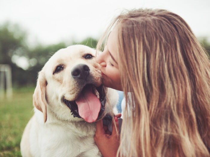 vrouw geeft hond een kus