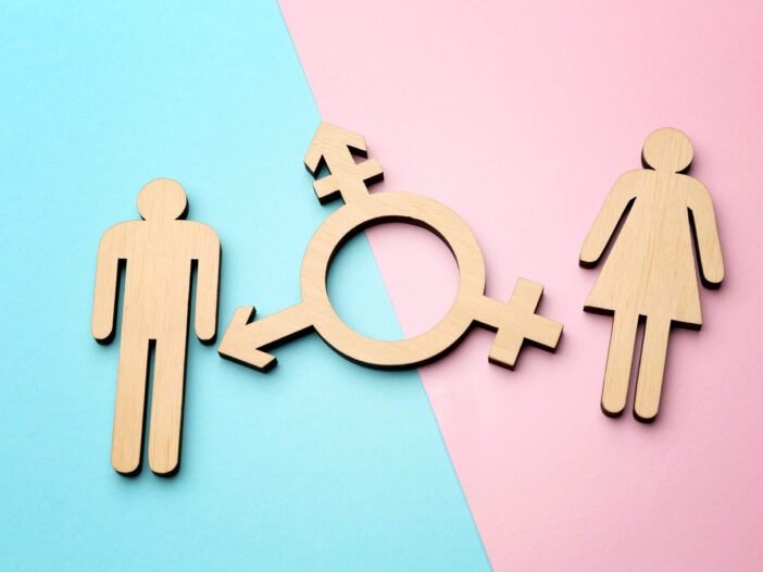 Female and male figures with symbol of transgender on color background