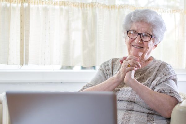 oudere vrouw maakt gebruik van laptop en lacht