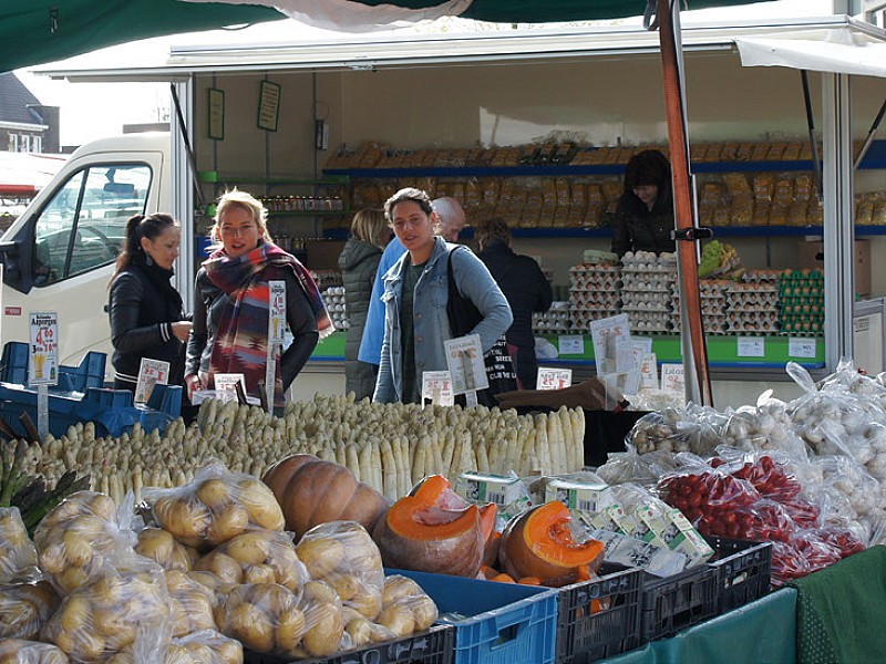 twee mensen bezoeken de groentekraam op een markt