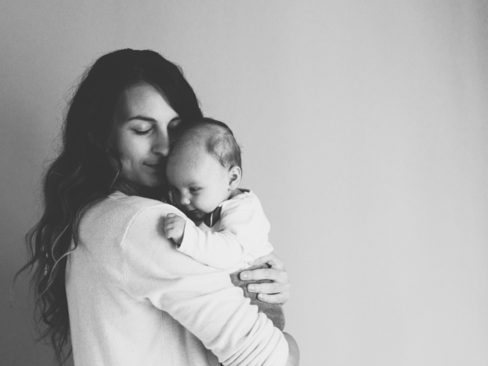 vrouw houdt haar baby vast in zwart-wit foto