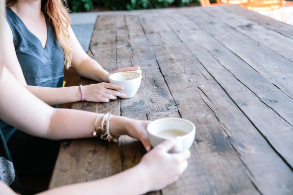 twee vrouwen aan tafel drinken samen koffie