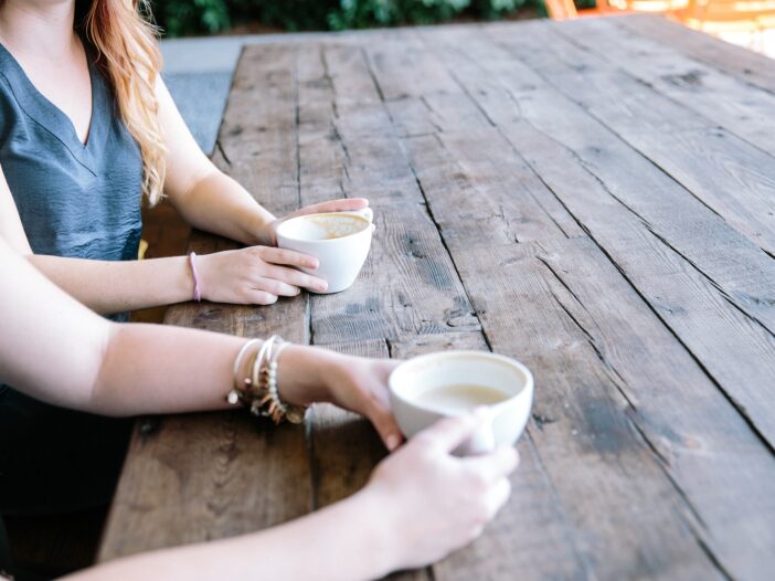 twee vrouwen aan tafel drinken samen koffie