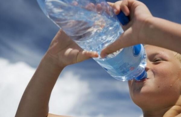 Jongen drink water uit fles