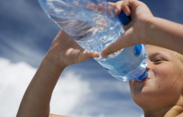 Jongen drink water uit fles