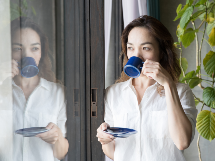 vrouw kijkt uit een raam