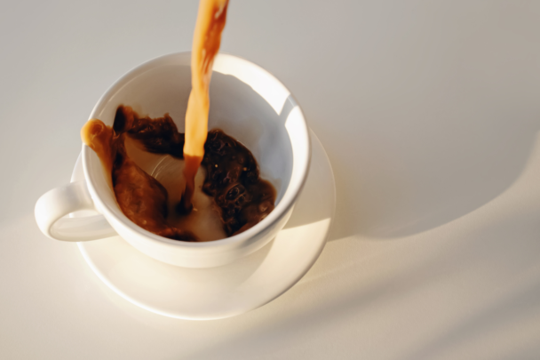 Koffie wordt ingeschonken in een wit glas. De koffie ziet er goed gefilterd uit.