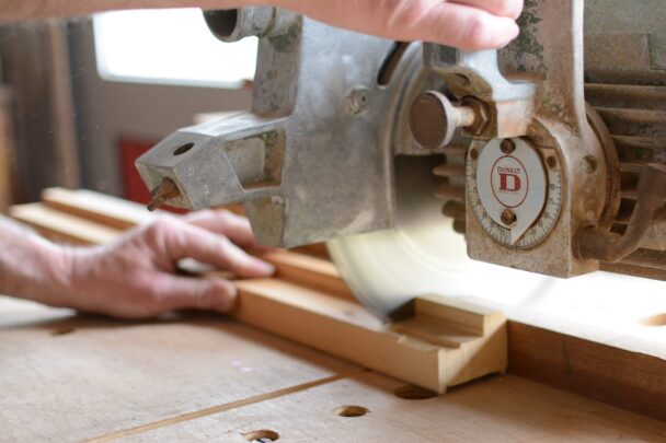 man gebruikt zaagmachine voor houten plank