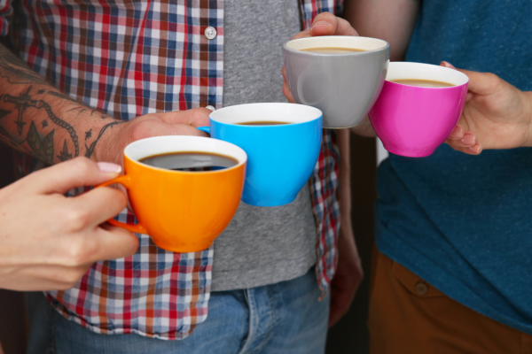 vier mensen hebben allemaal een kopje koffie vast