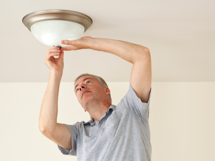 man die een lamp ophangt