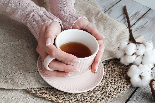 vrouwenhand houdt een kop thee vast