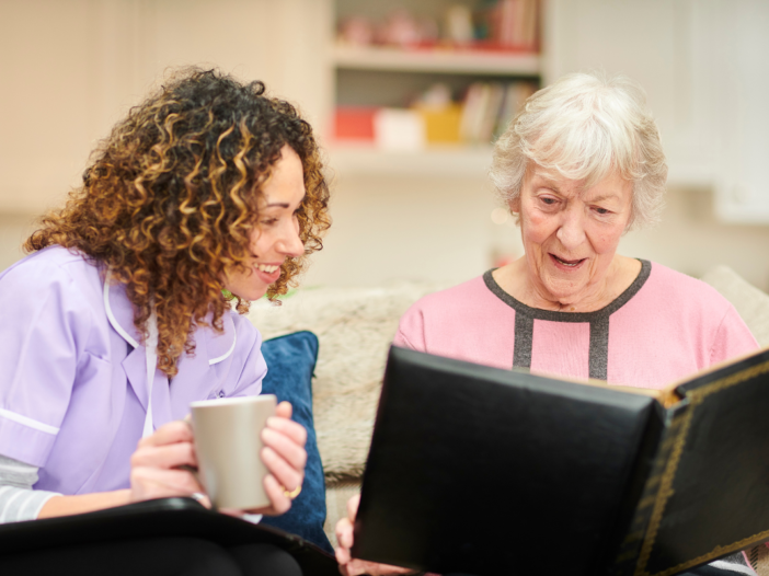 twee vrouwen die samen een fotoboek bekijken