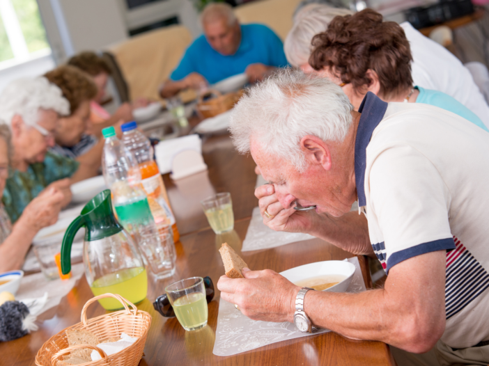 ouderen eten samen aan tafel een lunch