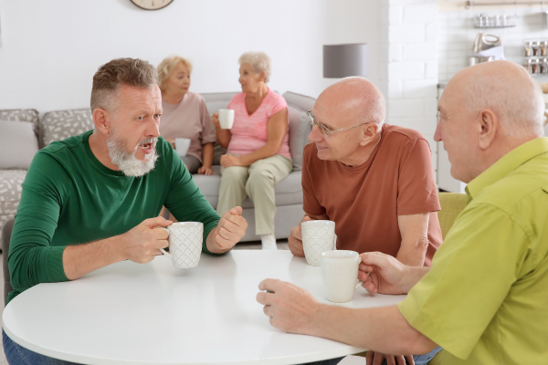 mannen zitten aan een tafel te kletsen met koffie