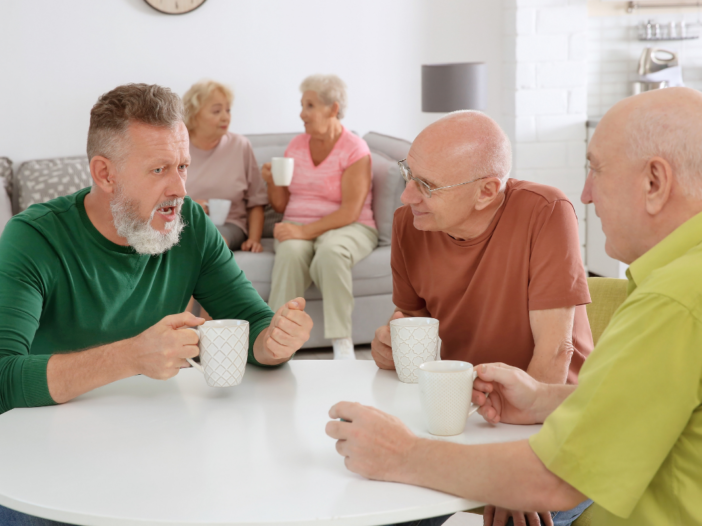 mannen zitten aan een tafel te kletsen met koffie