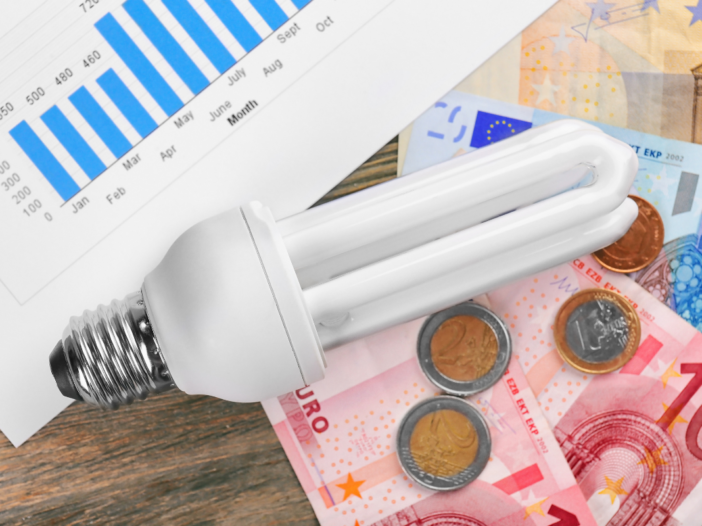 geld en een spaarlamp op een tafel