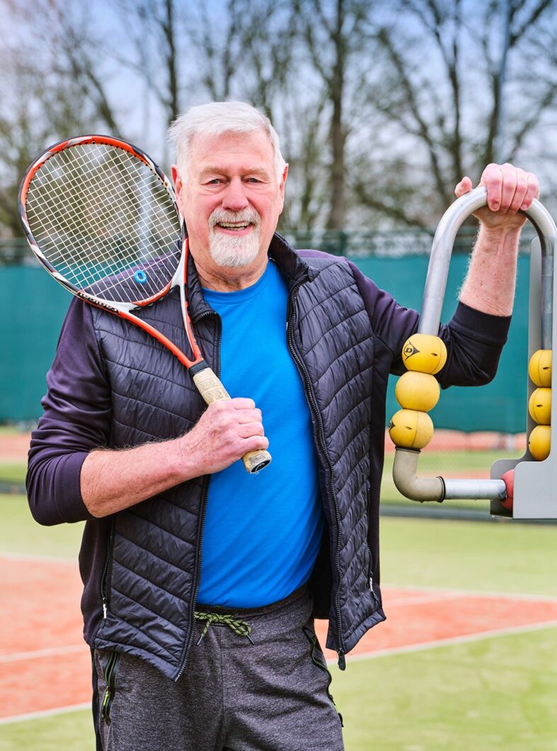 man op tennisbaan met racket in de hand