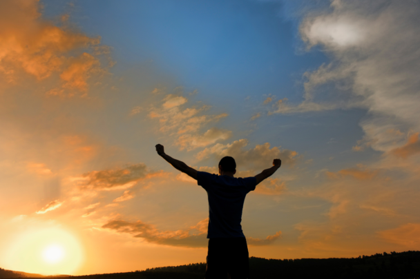 man staat met armen in de lucht in een power pose