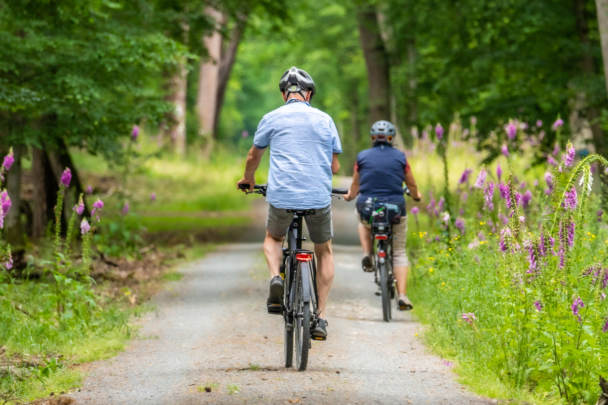 twee mensen samen op de fiets in het bos