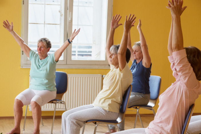 groepje ouderen doet aan stoelgym