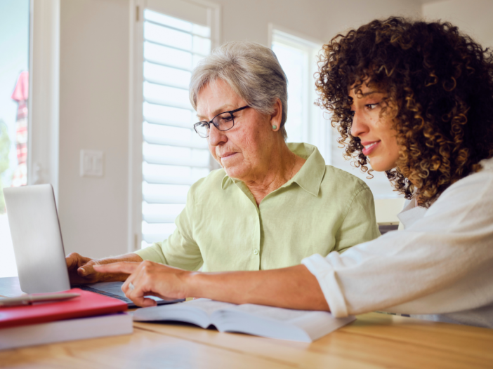 jonge en oudere vrouw maken samen gebruik van een computer