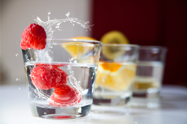 twee glazen water met stukjes fruit erin