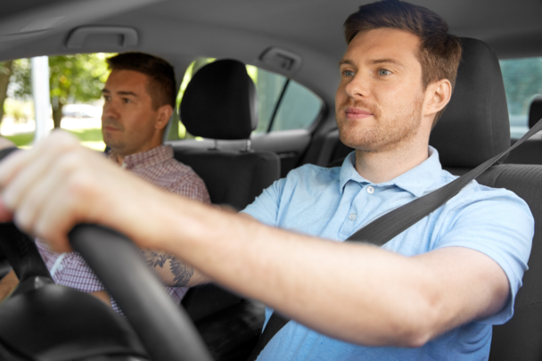 Vader en zoon samen in een auto. De zoon vervoert zijn vader.