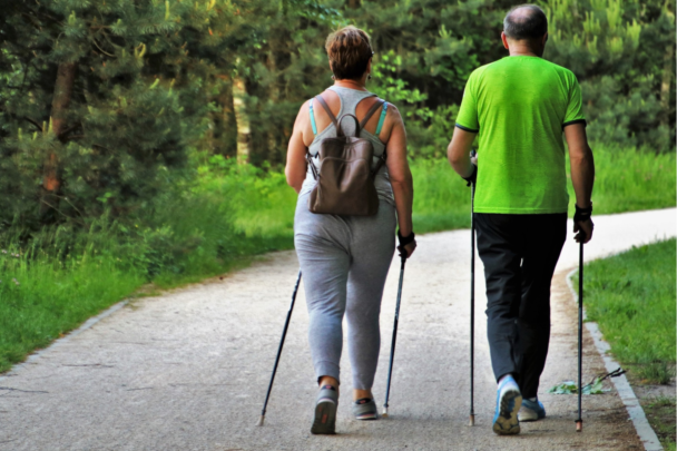 Man en vrouw wandelen samen met nordic walking stokken