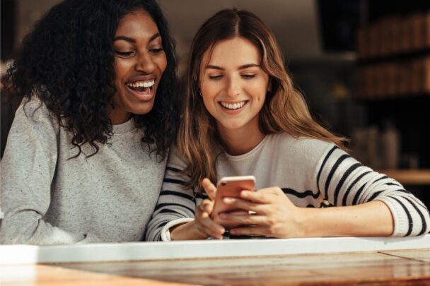 Twee vriendinnen kijken samen naar iets op een smartphone