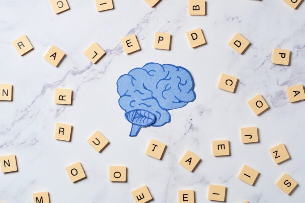 Illustratie van hersenen met scrabble letters er omheen.