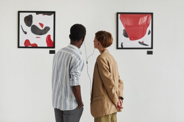 Man en vrouwen bekijken samen kunst aan een muur.