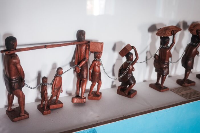 Houten beeldjes beelden slavernijperikelen uit.