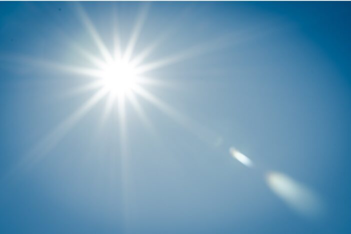 Felle zon met blauwe hemel.