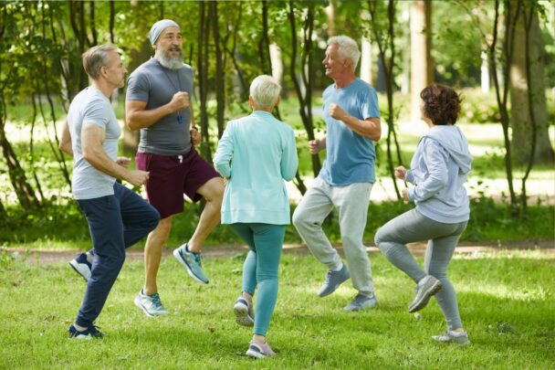 Ouderen sporten buiten op een grasveld.