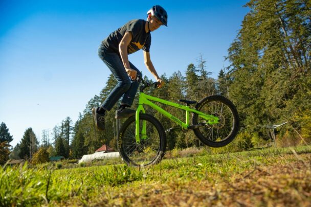 Man rijdt BMX op een grasveld.