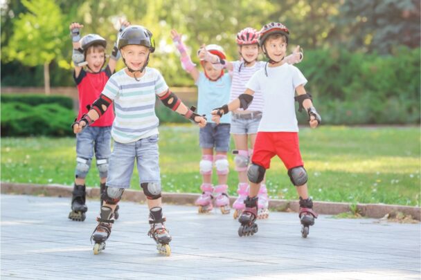 Vier kinderen skeeleren op asfalt.