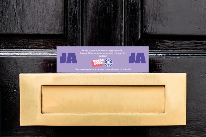 Ja-JA sticker boven de brievenbus van een zwarte voordeur