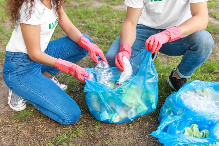 Twee jonge mensen ruimen samen afval.