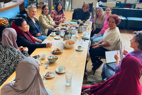Vrouwen van diverse achtergronden in gesprek met elkaar.