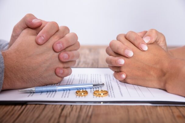 Man en vrouw zitten aan tafel met scheidingspapieren.