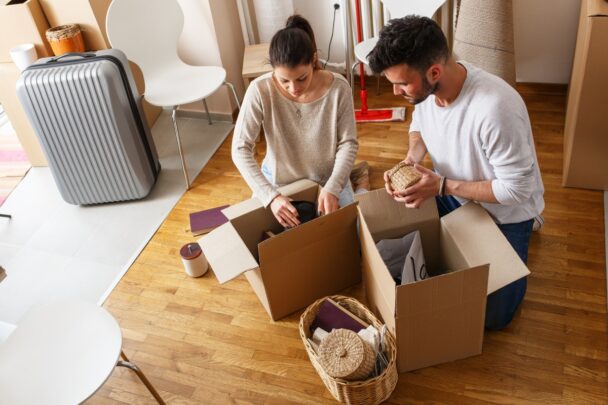 Man en vrouw pakken samen verhuisdozen uit.