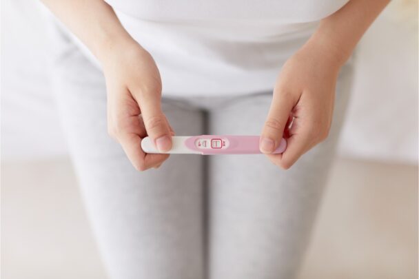 Vrouw leest een zwangerschapstest af.