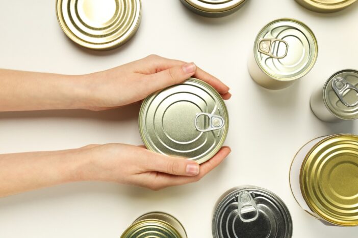 Vrouw houdt een blik in haar handen.