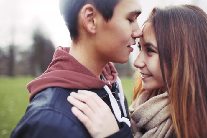 Tiener jongen en meisje houden elkaar vast.