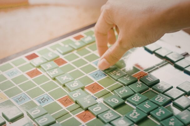 Vrouwelijke hand speelt een versie van scrabble met cijfers.