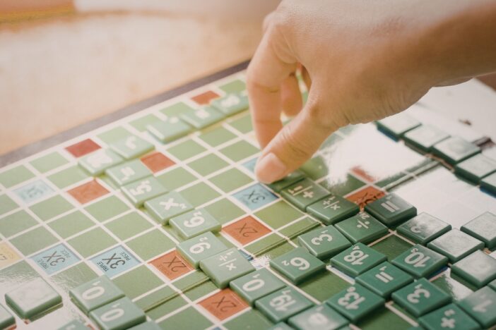Vrouwelijke hand speelt een versie van scrabble met cijfers.