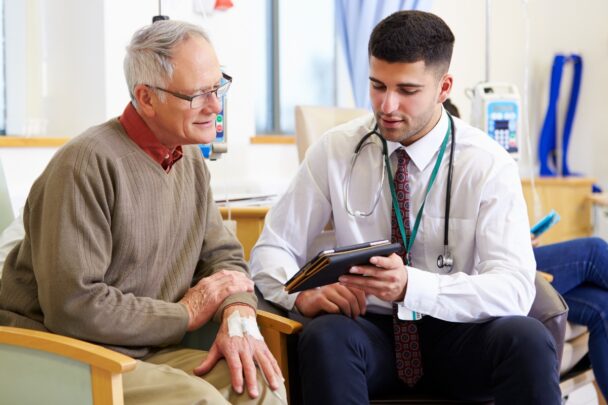 Arts legt iets uit aan oudere patiënt.