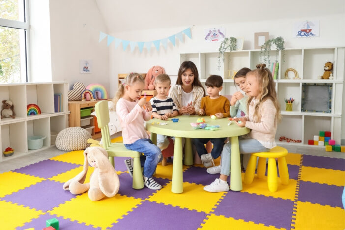 Groepje kindjes zit aan tafel op een kinderopvang.